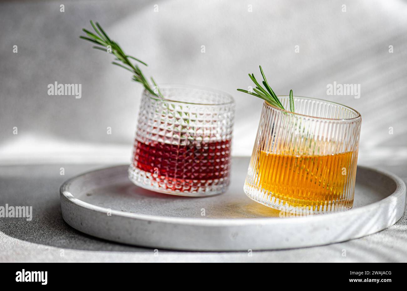 Zwei Cocktails in strukturierten Gläsern, einer mit Kirsch- und ... Zwei Cocktails in strukturierten Gläsern, einer mit Kirsch- und ...