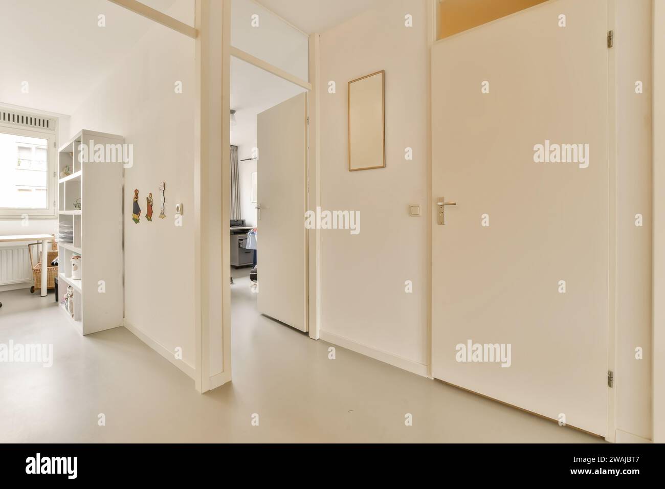 Innenraum des leeren Flurs mit weißen Türen, die zu verschiedenen Zimmern in einem modernen Apartment mit hellen Wänden und Boden führen Stockfoto