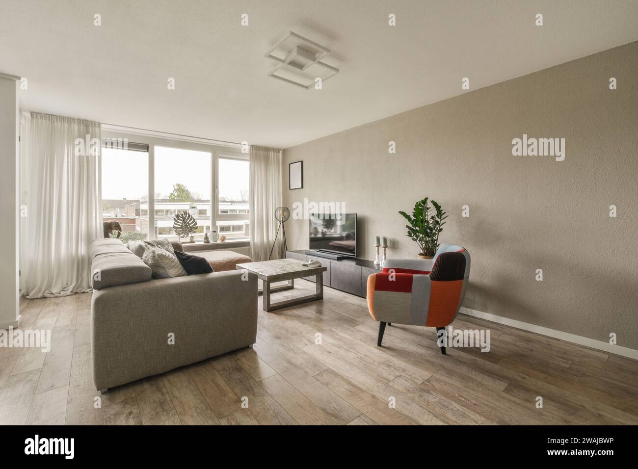 Großes komfortables Sofa und Couchtisch vor dem Fernseher im geräumigen Wohnzimmer des luxuriösen Apartments Stockfoto