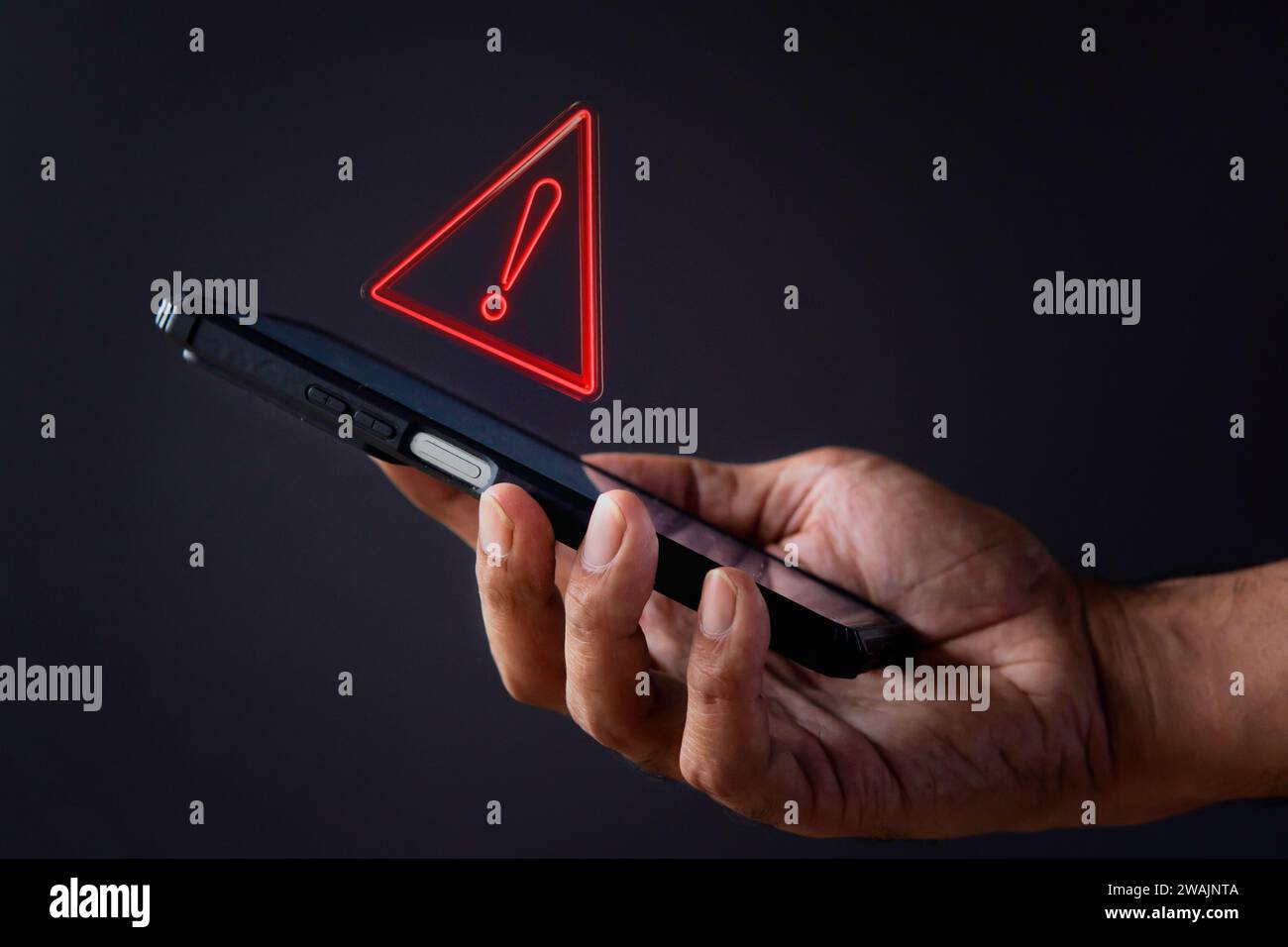 Smartphone mit Dreieck-Warnsymbol. Systemfehler, Malware und Cyberkriminalität. Stockfoto