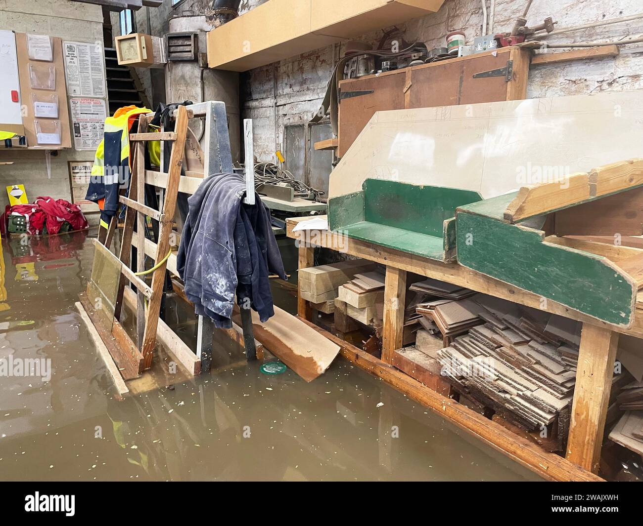 Hochwasser in Kirk and Bill's, einer Möbelwerkstatt in Newark-on-Trent, Nottinghamshire. Wasser ist durch die Dielen und Abflüsse aufgrund der Überschwemmung durch Sturm Henk gestiegen, die die Werkstatt überschwemmt hat. Bilddatum: Freitag, 5. Januar 2024. Stockfoto