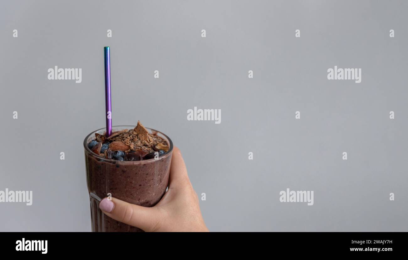 Eine Nahaufnahme einer Frau, die ein Glas cremigen Schokoladen-Milchshake packt Stockfoto