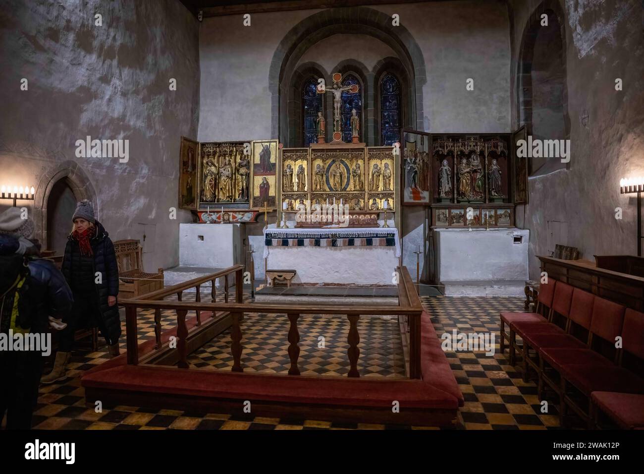 Trondenes, Norwegen. November 2023. Touristen spazieren um den Hauptaltar der mittelalterlichen Kirche von Tondenes, die um 1435 erbaut wurde und für ihre historische Architektur und kulturelle Bedeutung bekannt ist. Trondenes ist eine Stadt im Norden Norwegens in der Region Troms og Finnmark. Umgeben von einer atemberaubenden arktischen Landschaft mit Fjorden und Bergen hat die Region eine reiche Fischertradition. Trondenes zieht Besucher an, die sich für Geschichte und natürliche Schönheit interessieren. (Foto: Jorge Castellanos/SOPA Images/SIPA USA) Credit: SIPA USA/Alamy Live News Stockfoto