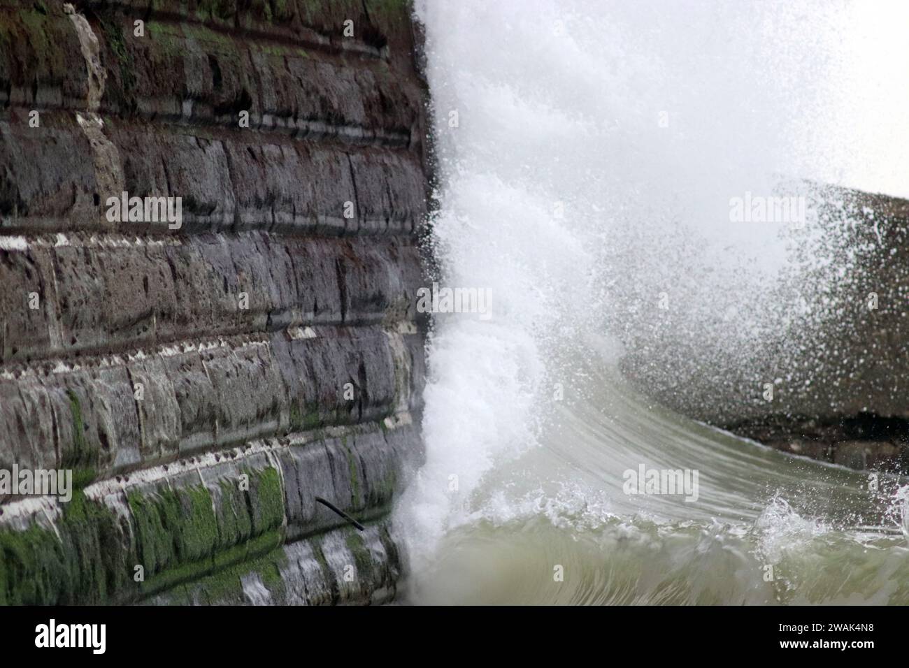Wellen treffen auf die Meeresmauer Stockfoto