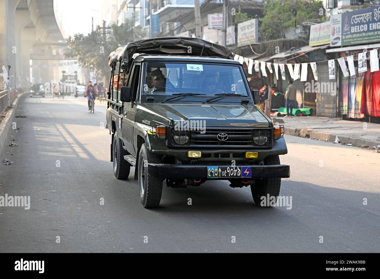 Dhaka, Bangladesch, am 5. Januar 2024. Bangladesch-Armeeangehörige sitzen auf der Rückseite eines Fahrzeugs, während sie in einer Straße für die bevorstehenden 12. Unterhauswahlen am 5. Januar 2024 in Dhaka, Bangladesch, patrouillieren. Die Aufgaben der Wahlsicherheit haben begonnen, für eine friedliche Atmosphäre und die Aufrechterhaltung von Recht und Ordnung im ganzen Land für die Wahlen vom 7. Januar 2024 zu sorgen. Stockfoto