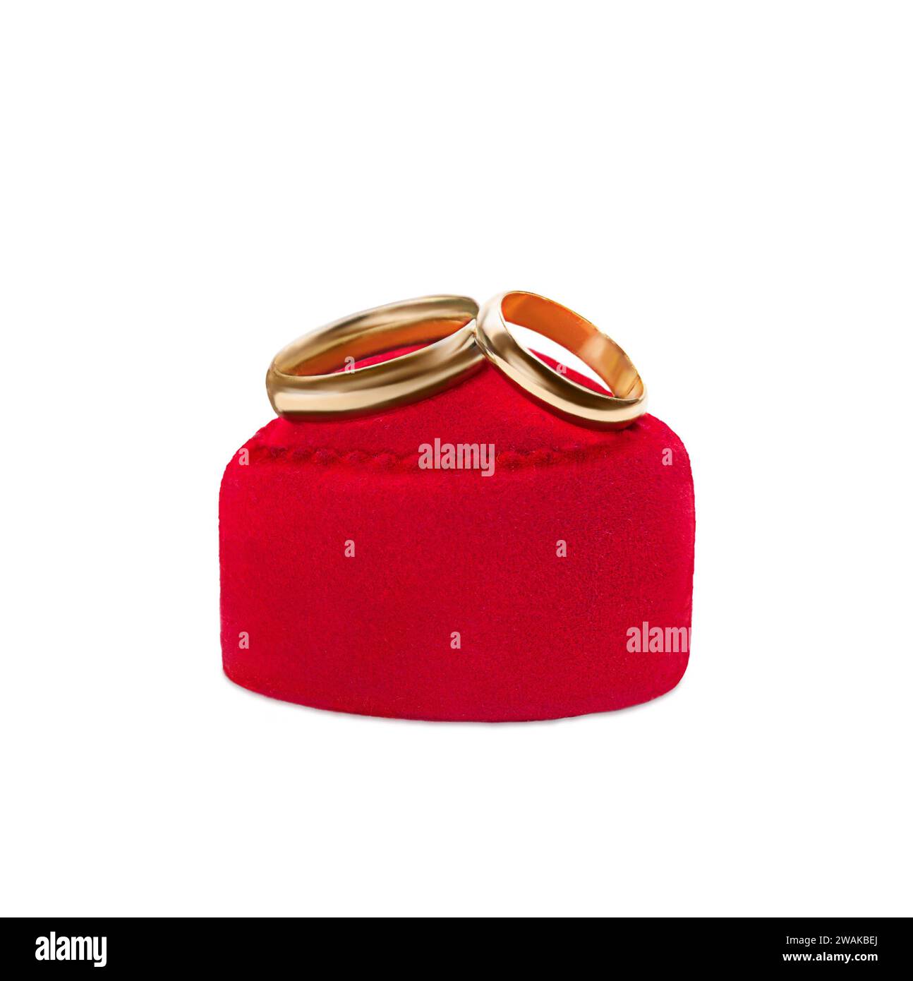 Goldene Eheringe auf rotem Samtgeschenkkasten Herz auf weißem Hintergrund. Ehe, Vorschlag, Valentinstag. Vertikal. Kopierbereich Stockfoto