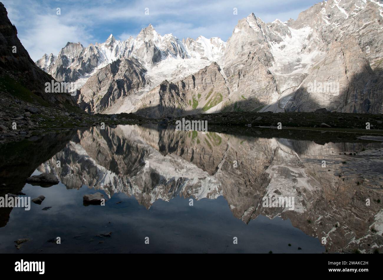 Pakistan, nördliche Gebiete der Karakorum Mountains. Ein bildliches Bild mit Blick über einen Gletscherteich im Gondogoro-Tal zu den unbenannten Gipfeln der Karakorum-Berge. Stockfoto