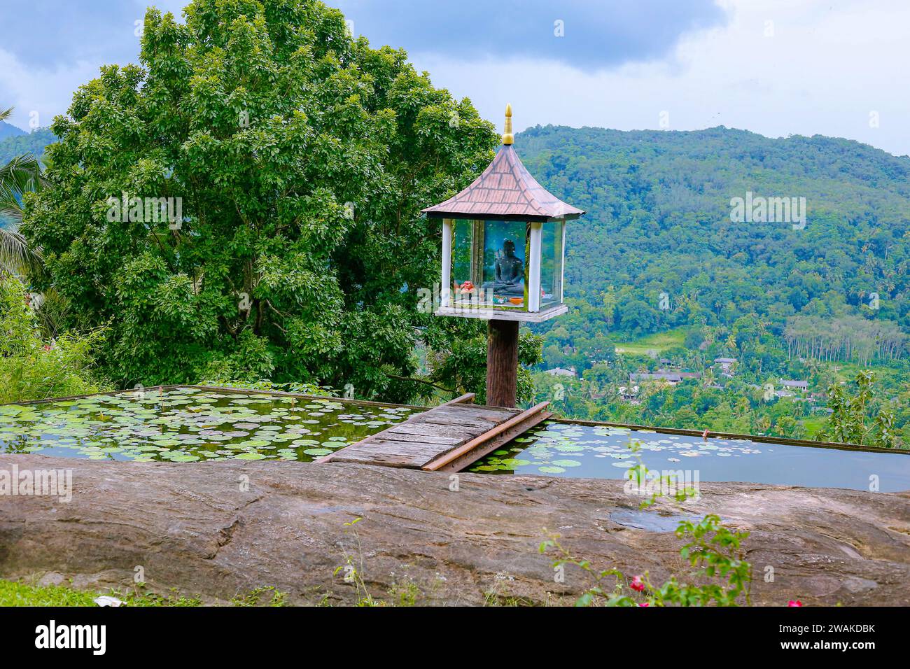 Eine kleine Buddha-Statue inmitten einer wunderschönen hügeligen Landschaft in kandy, sri lanka Stockfoto