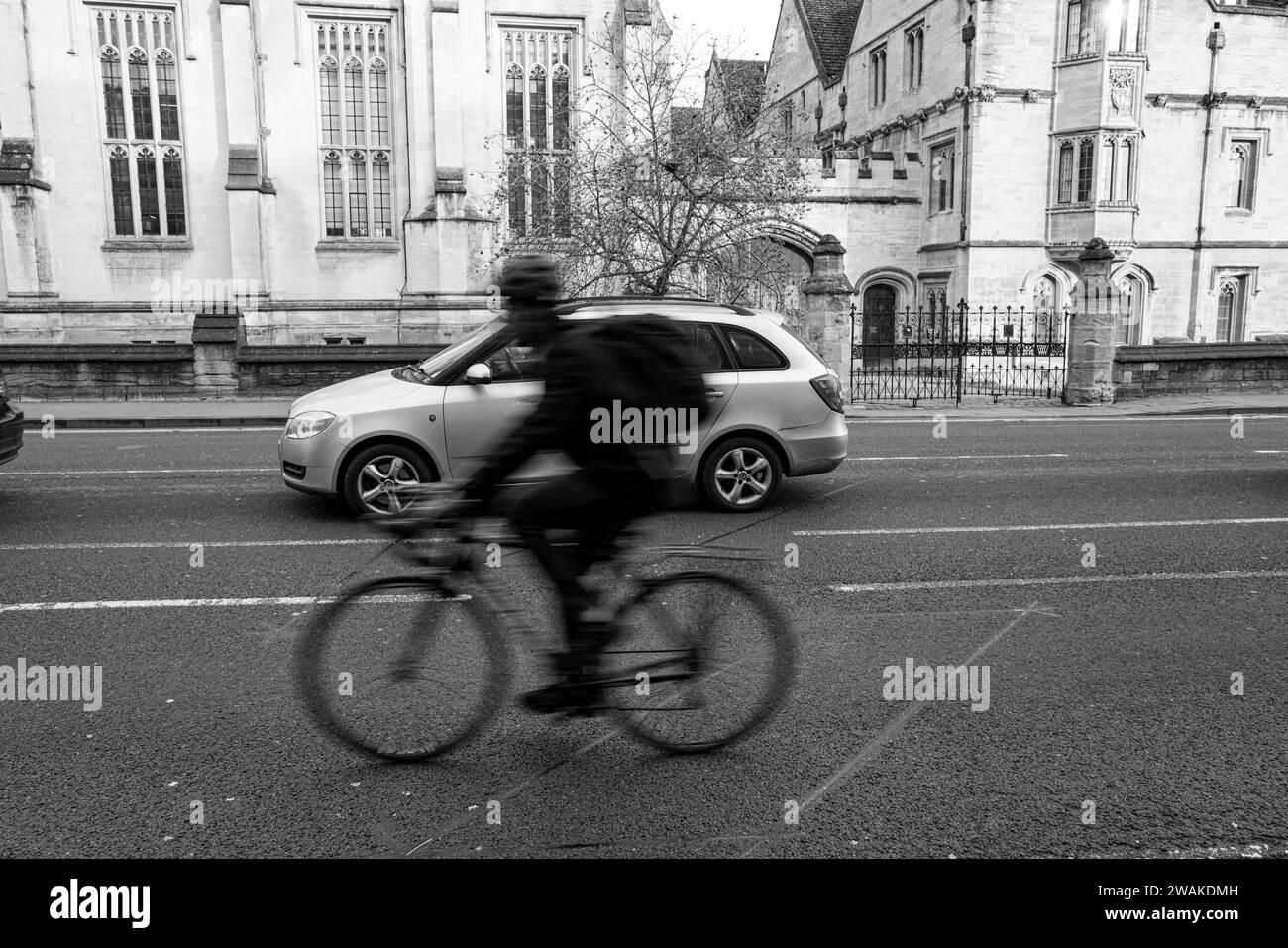 Ein Radfahrer und ein Auto passieren das Magdalen College auf dem Weg nach Oxford England Stockfoto