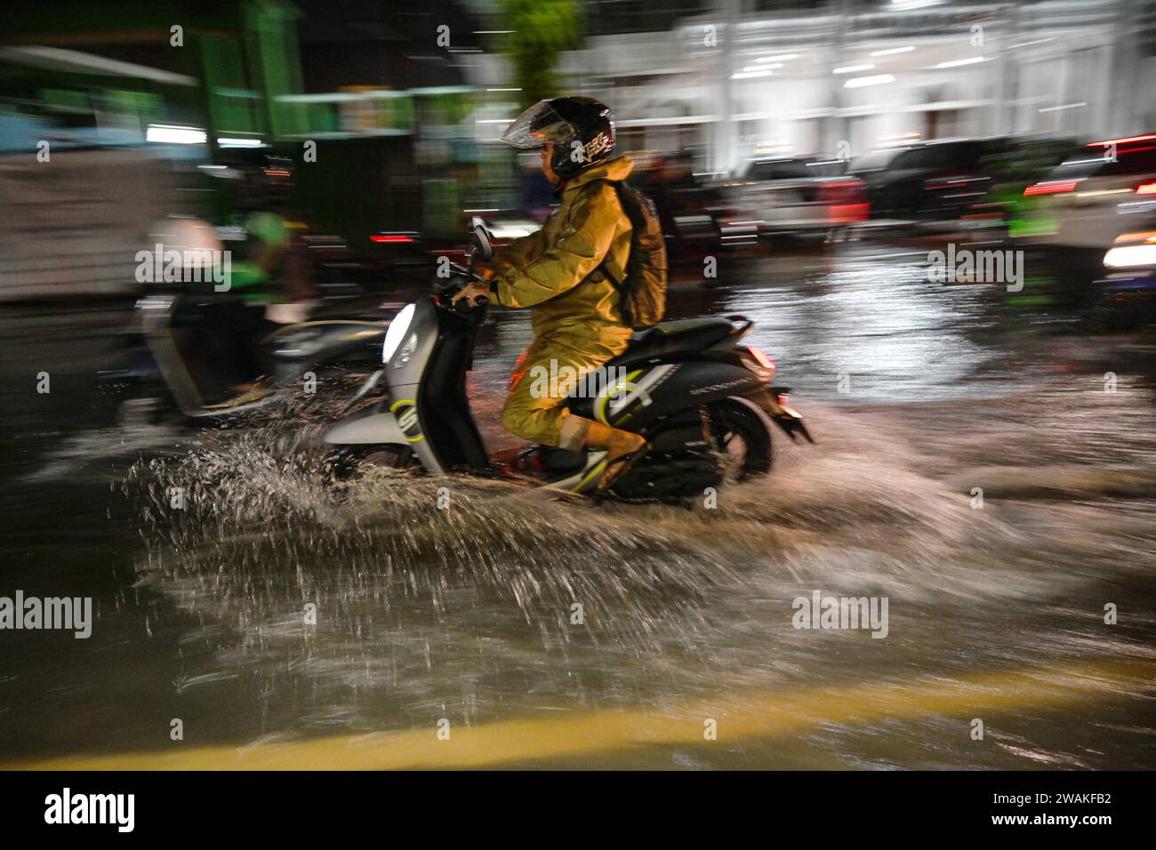 Süd-Tangerang, Indonesien. Januar 2024. Autofahrer waten nach starkem Regen am 5. Januar 2024 durch Hochwasser in Süd-Tangerang, Provinz Banten, Indonesien. Die indonesische Agentur für Meteorologie, Klimatologie und Geophysik (BMKG) gab am Mittwoch eine Warnung an die Öffentlichkeit aus und forderte zur Vorsicht auf, da in mehreren Großstädten des Landes vom 3. Bis 10. Januar extreme Wetterereignisse auftreten können. Quelle: Agung Kuncahya B./Xinhua/Alamy Live News Stockfoto