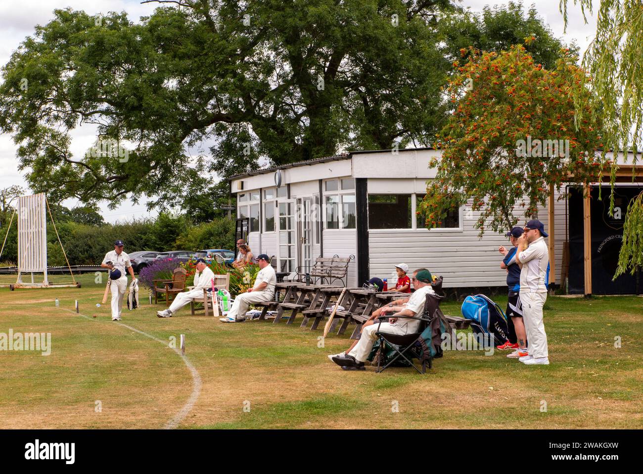 Großbritannien, England, Oxfordshire, Fringford, Cricket Club Cricketspieler beobachten das Spiel vom Pavillon aus Stockfoto