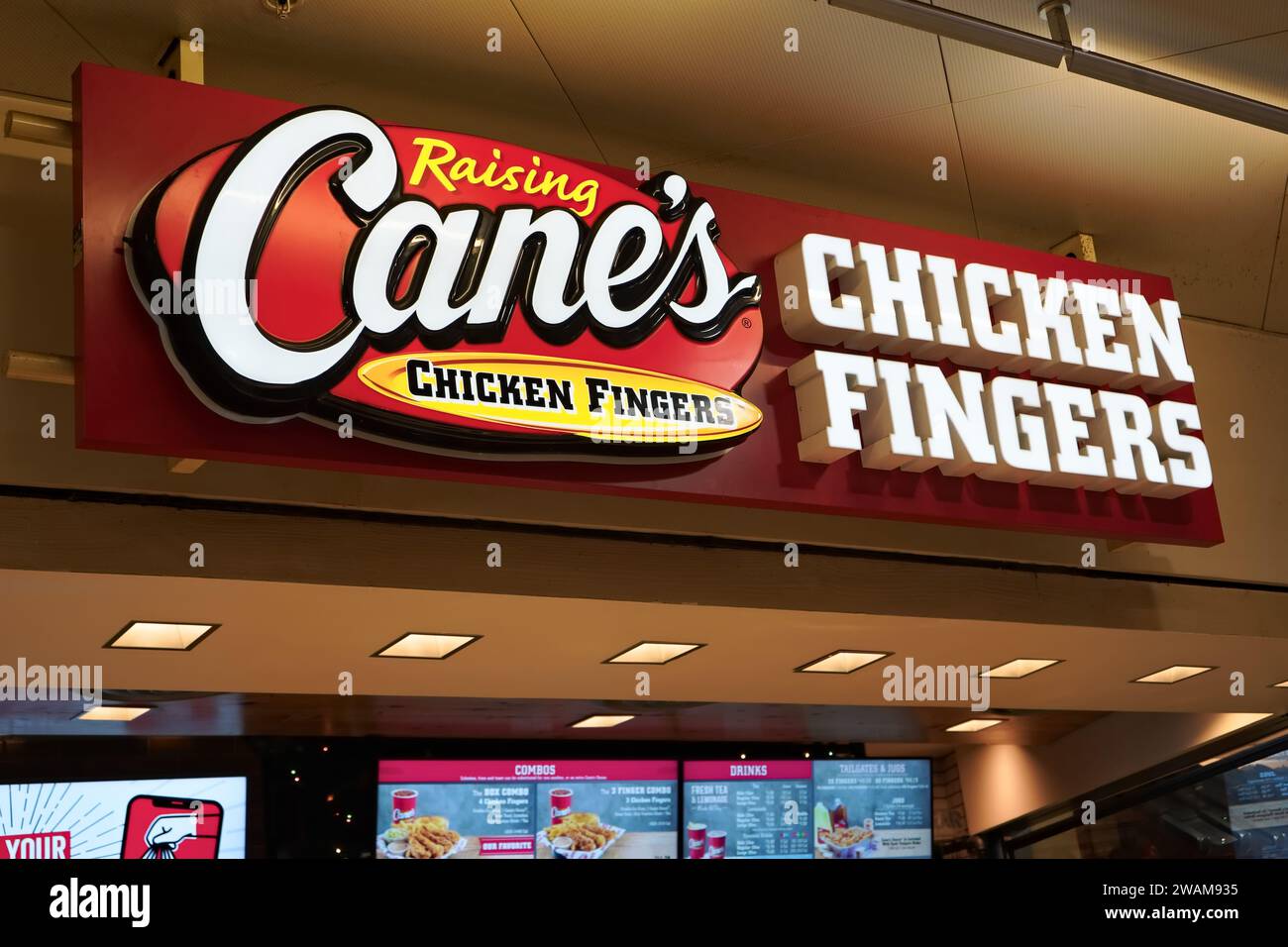 Honolulu, HI - 24. Dezember 2023: Raising Cane's Chicken Fingers Fast Food Chain Signage am Food Court in Ala Moana Stockfoto