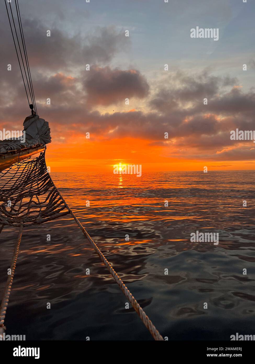 Orangefarbener Sonnenaufgang über dem Atlantik von einem hohen Schiffsbogen aus gesehen Stockfoto