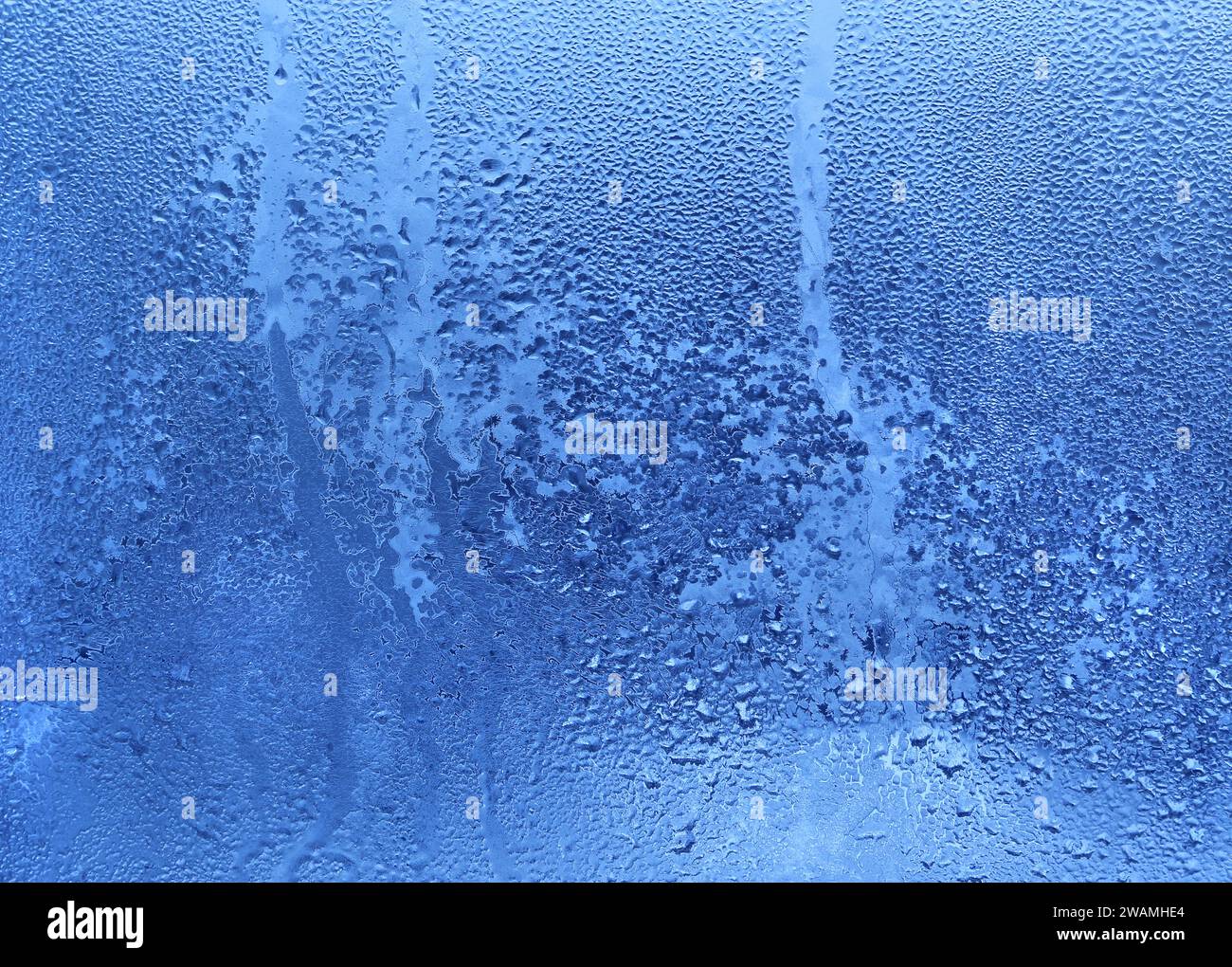 Naturhintergrund mit gefrorenen Wassertropfen auf Fensterglas Stockfoto