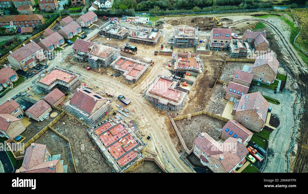 Luftaufnahme eines im Bau befindlichen Wohngebäudes mit teilweise gebauten Häusern und Infrastruktur. Stockfoto