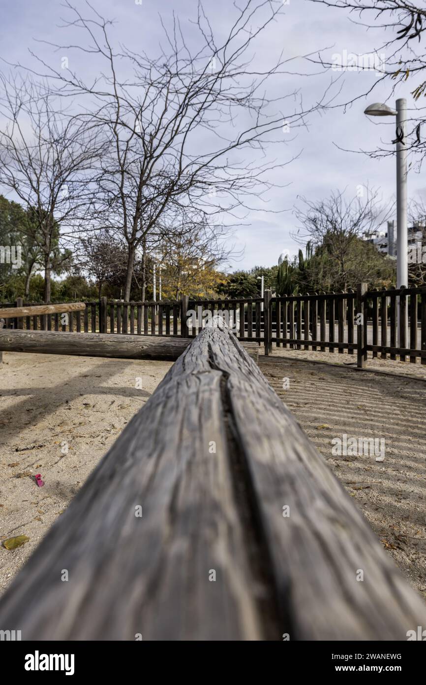 Einige große, unbehandelte Holzstämme wurden als Spiele für Kinder in einem umzäunten Park verwendet Stockfoto