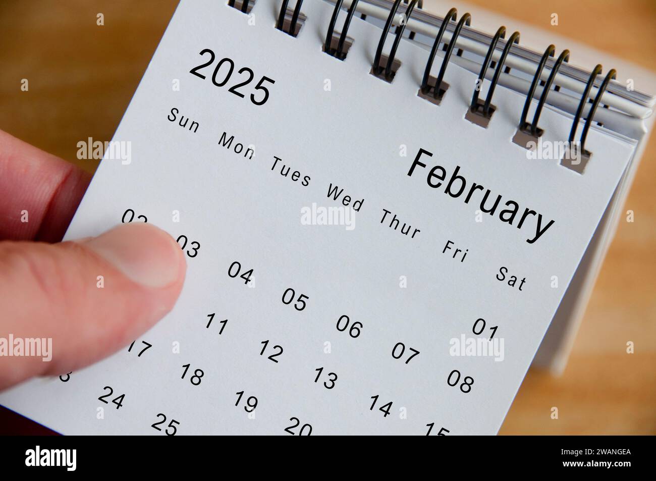 Nahaufnahme des Kalender Februar 2025 auf hölzernem Schreibtischhintergrund. Kalenderkonzept. Stockfoto