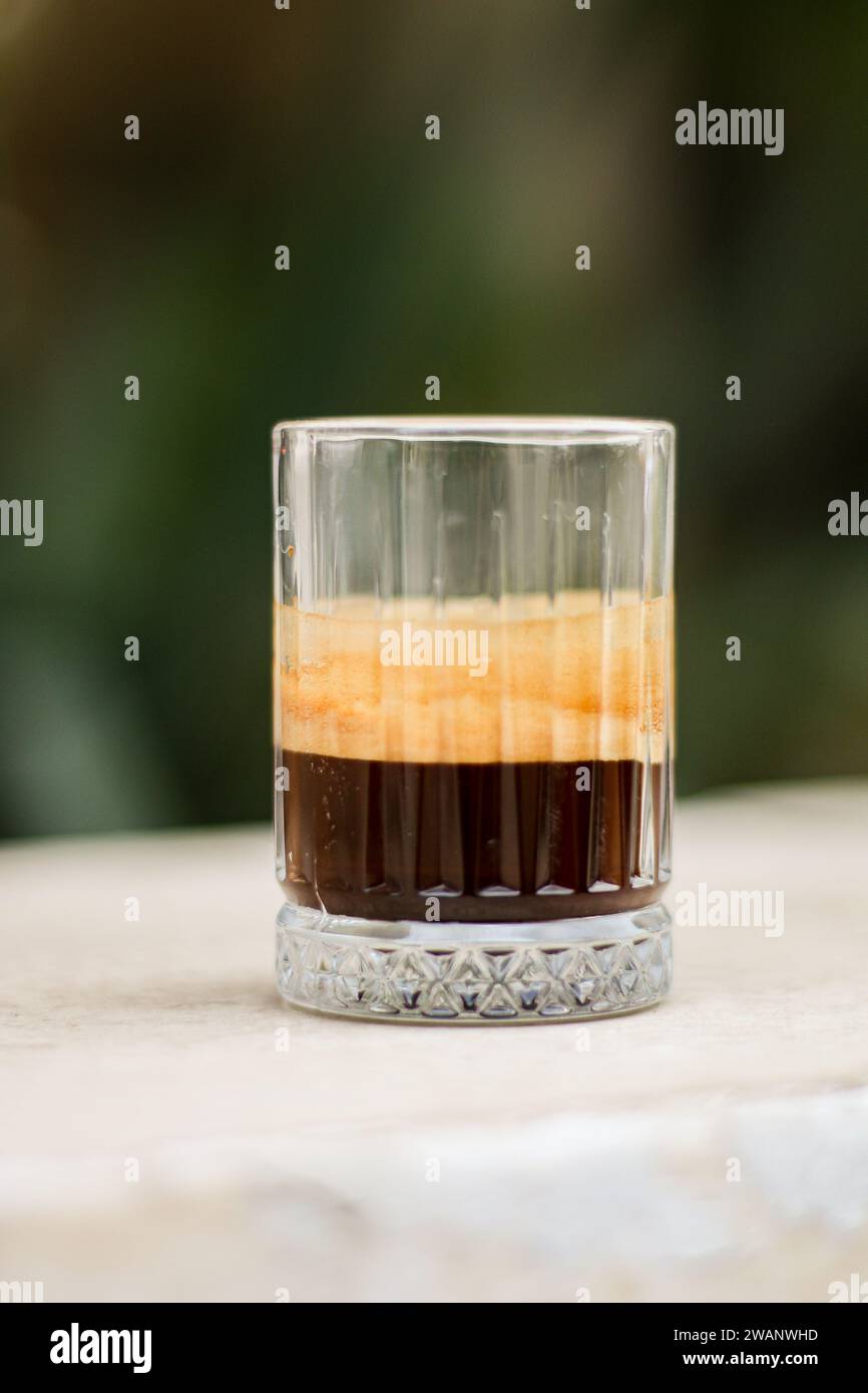 Schokoladenkeks und Kaffee in Glasbecher auf rustikalem Holzhintergrund. Nahaufnahme. Stockfoto