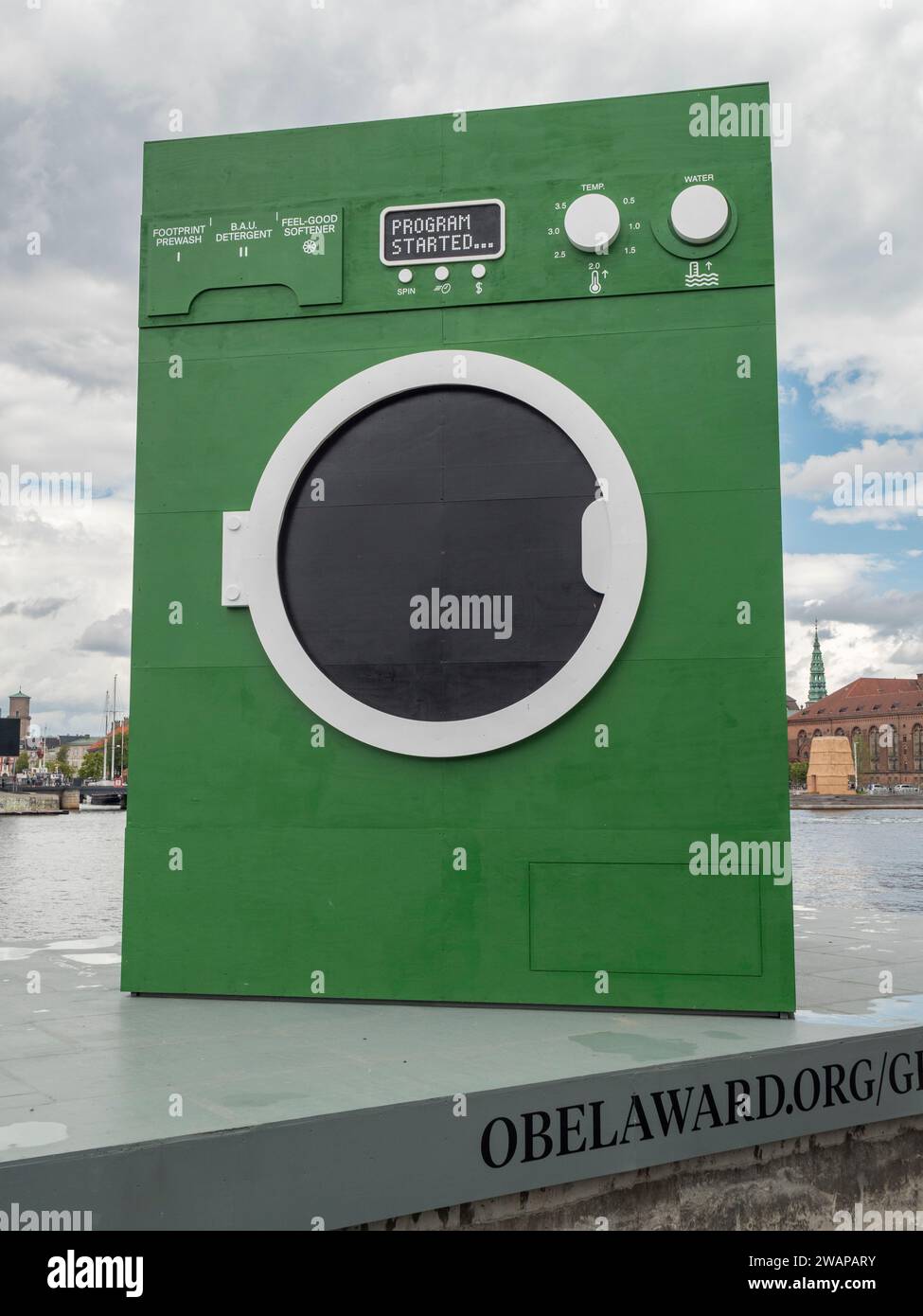 Eine riesige grüne Waschmaschine beim Maststudio, die die Praxis des Grünwaschens karikiert, schwimmt auf einem Lastkahn in Kopenhagen, Dänemark. Stockfoto
