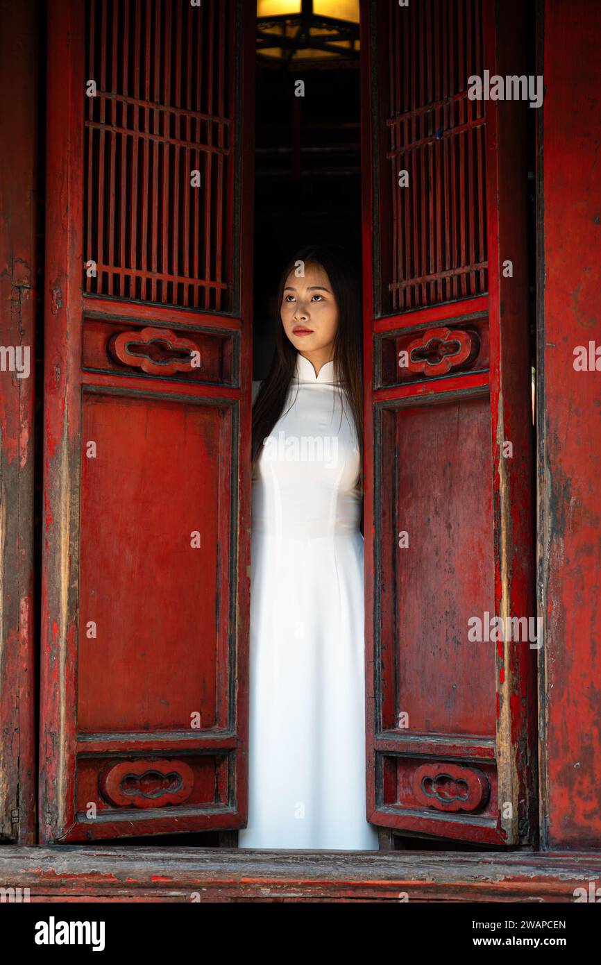 Porträt einer Frau in traditionellem vietnamesischem Ao Dai-Kleid im Tempel der Literatur, Hanoi, Vietnam Stockfoto