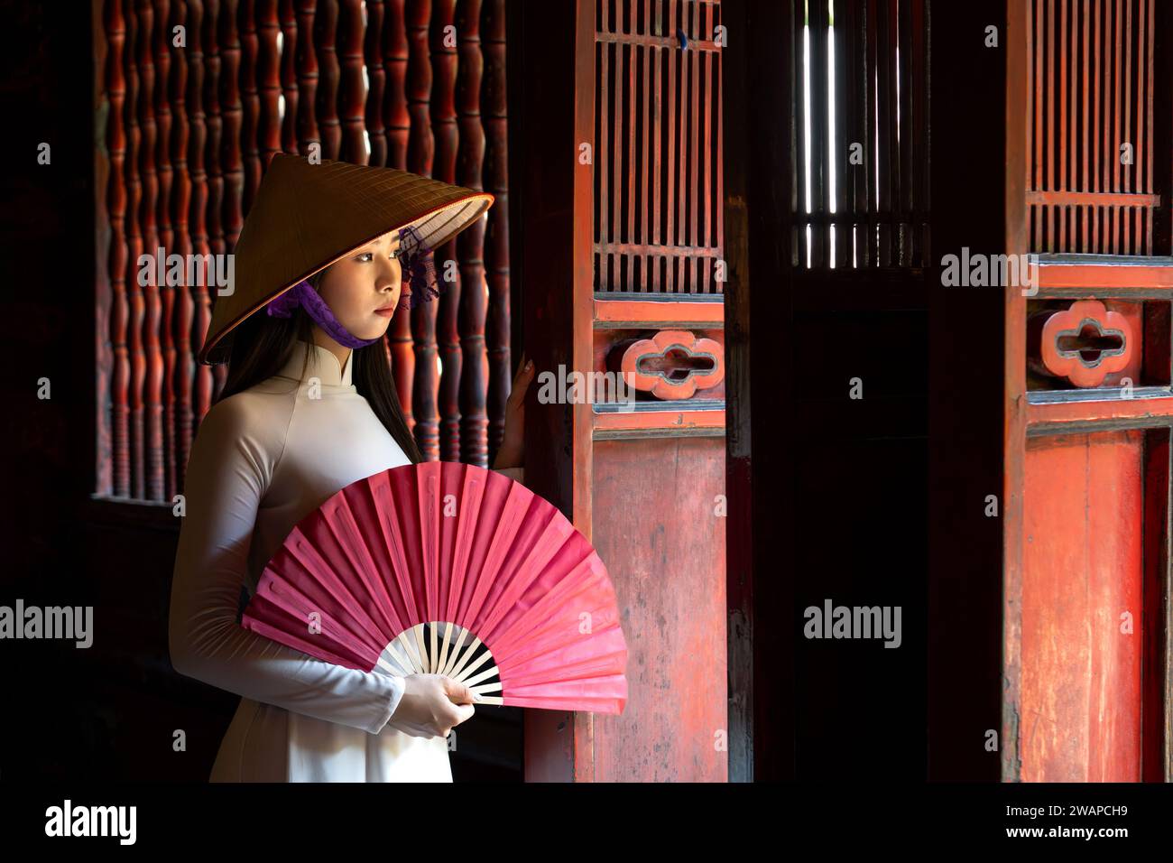 Porträt einer Frau in traditionellem vietnamesischem Ao Dai-Kleid im Tempel der Literatur, Hanoi, Vietnam Stockfoto