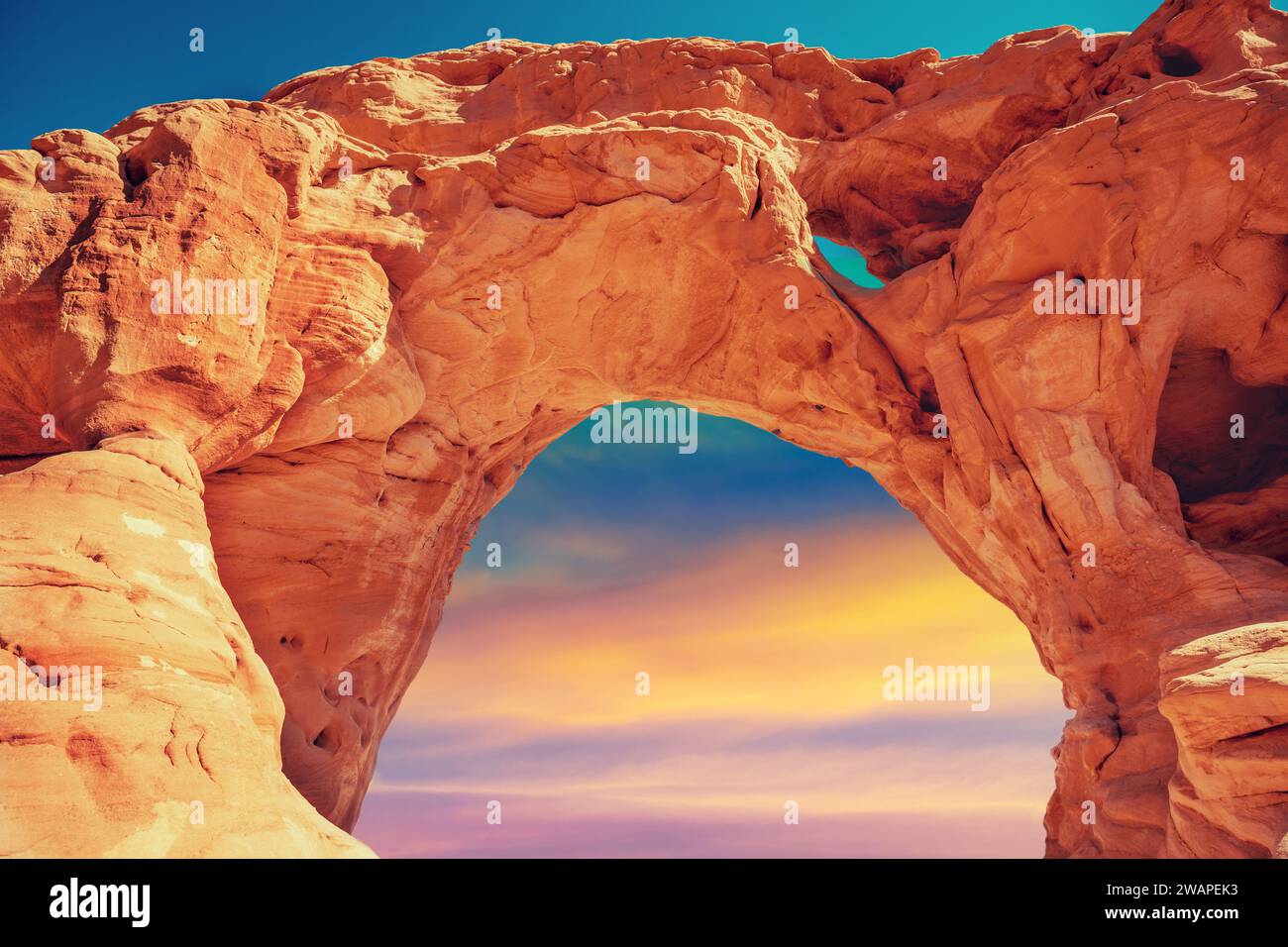 Bogen in den Felsen gegen den farbenfrohen Sonnenuntergang Himmel. Wüstenlandschaft. Timna Park. Israel Stockfoto