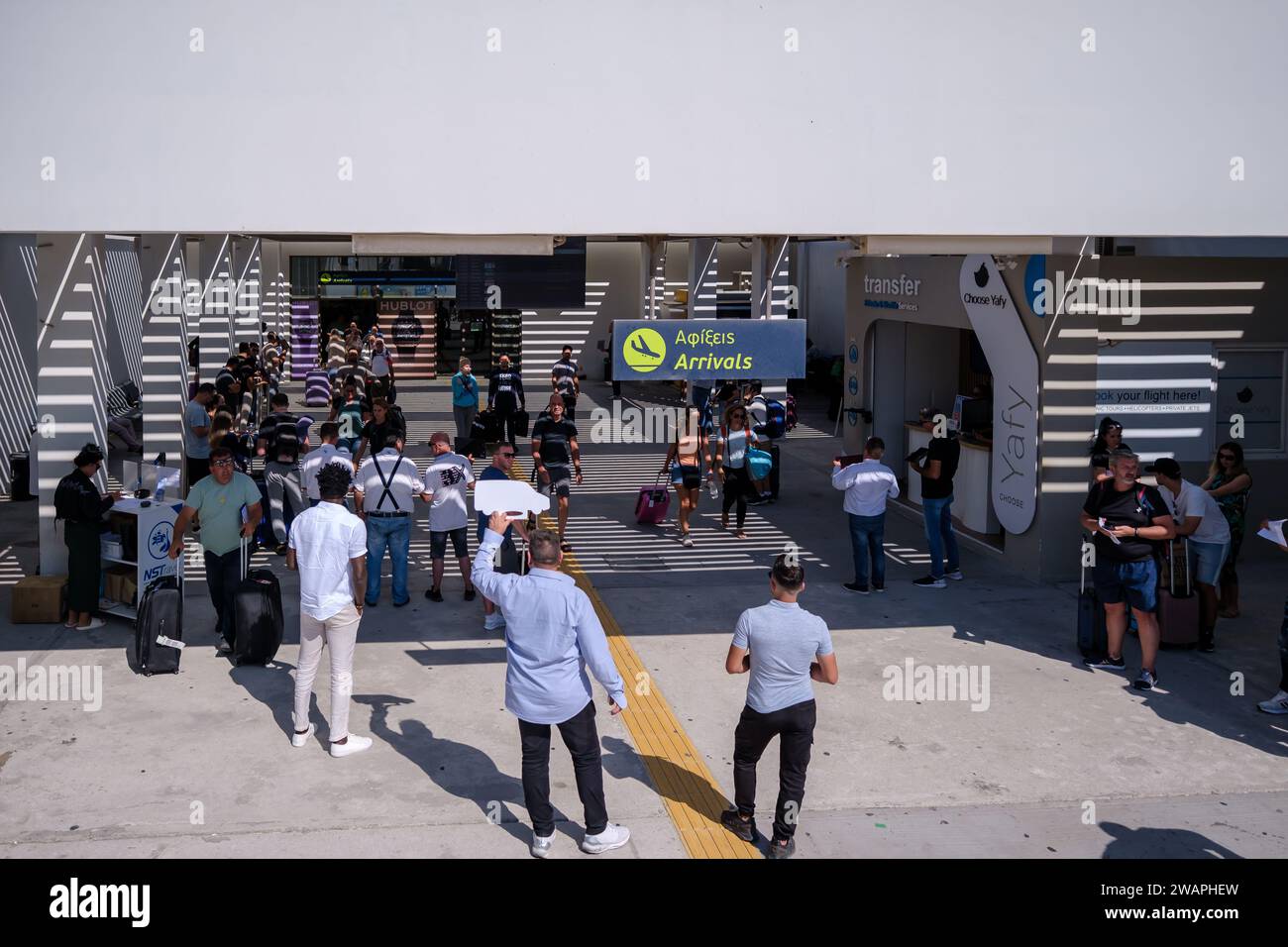 Santorin, Griechenland - 19. September 2023 : Ansicht der Menschen mit Schildern mit Namen von Touristen, die Transferservice am Flughafen von Santorin gebucht haben Stockfoto