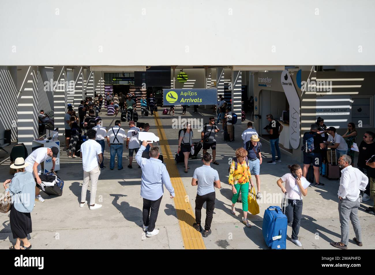 Santorin, Griechenland - 19. September 2023 : Ansicht der Menschen mit Schildern mit Namen von Touristen, die Transferservice am Flughafen von Santorin gebucht haben Stockfoto