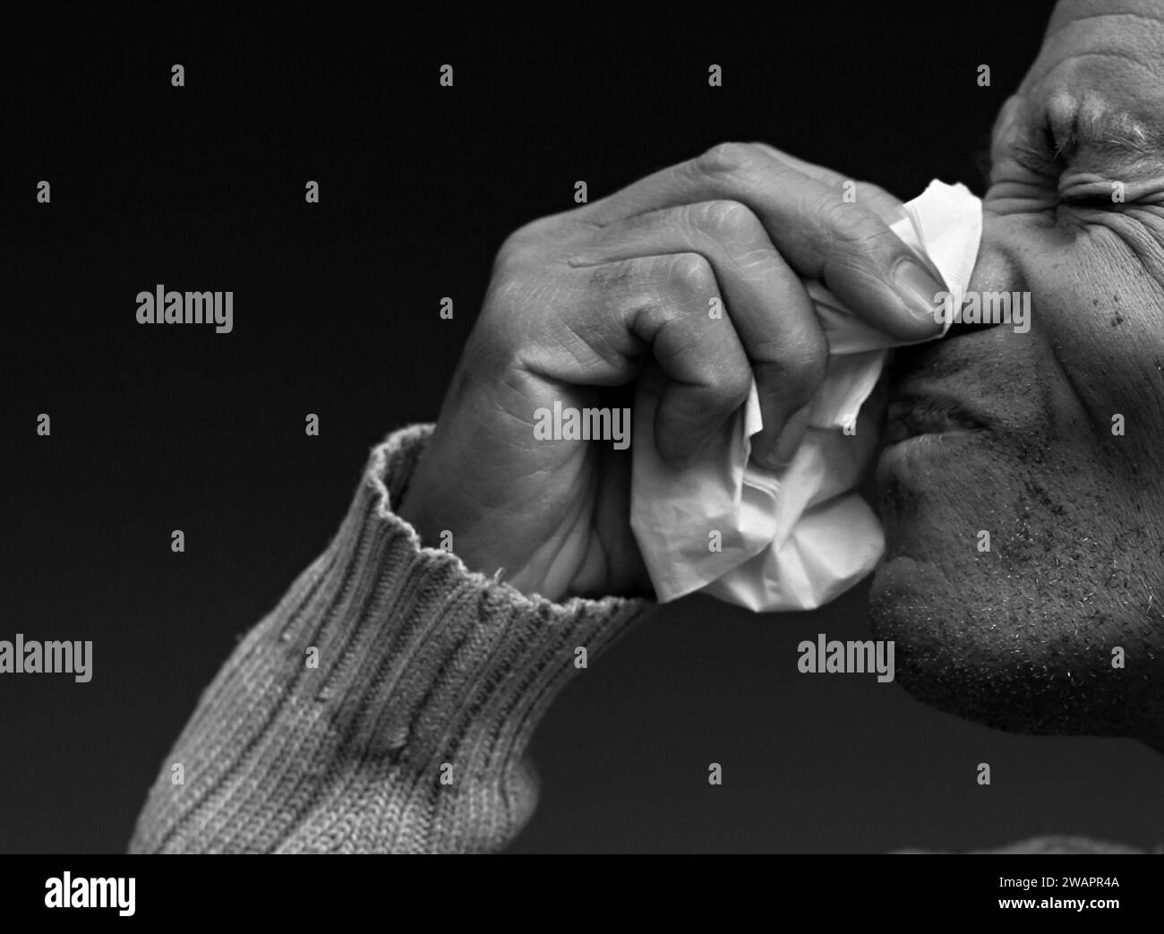 Blasen der Nase nach dem Fangen der Erkältung und Grippe mit grauem Hintergrund mit Menschen Stockfoto Stockfoto