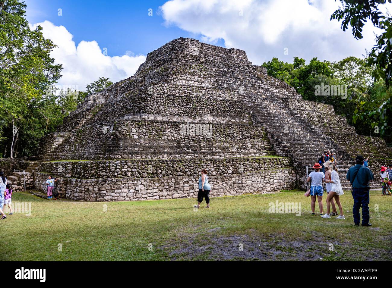 Ein majestätischer Blick auf die Ruinen der Maya-Ruinen von Chacchoben mit Touristen in der Nähe Stockfoto