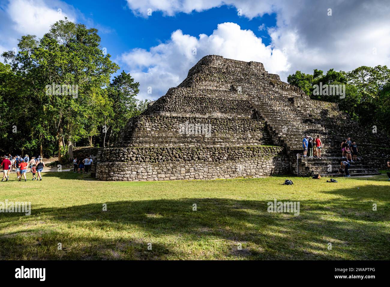 Ein majestätischer Blick auf die Ruinen der Maya-Ruinen von Chacchoben mit Touristen in der Nähe Stockfoto