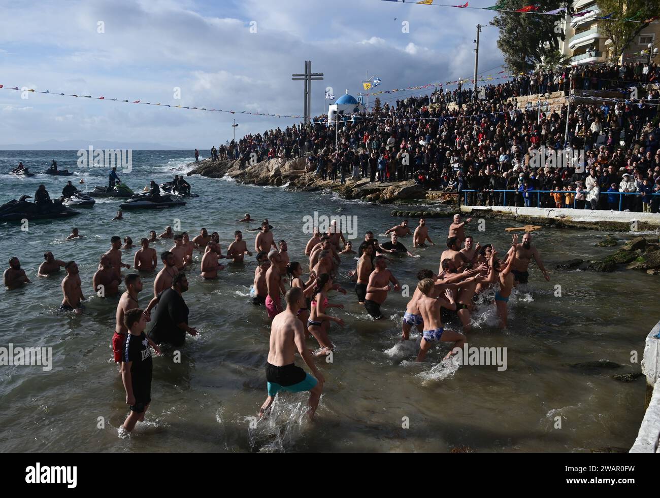 Piräus, Athen, Griechenland. Januar 2024. Schwimmer versuchen, während einer Wassersegnungszeremonie zur Feier der Epiphanienfeier ein hölzernes Kruzifix zu fangen. Die Zeremonien zur Feier der Epiphanik fanden im ganzen Land an Flussufern, Meeresfronten und Seen statt, wo christlich-orthodoxe Priester ein Kreuz ins Wasser werfen und Schwimmer um die Rettung kämpfen. Quelle: Dimitris Aspiotis/Alamy Live News Stockfoto