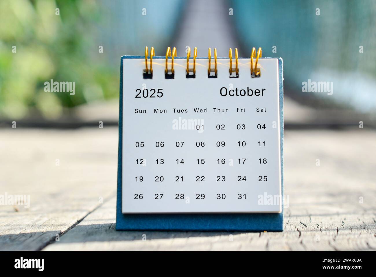 Weißer Kalender vom Oktober 2025 mit grünem verschwommenem Hintergrund