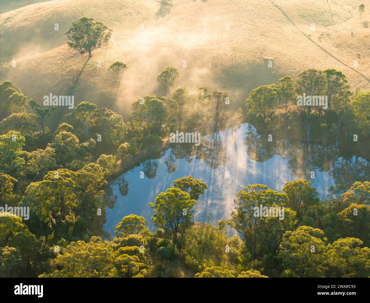 Ein atemberaubender Blick auf einen ruhigen Teich auf einem nebelbedeckten Berggipfel Stockfoto