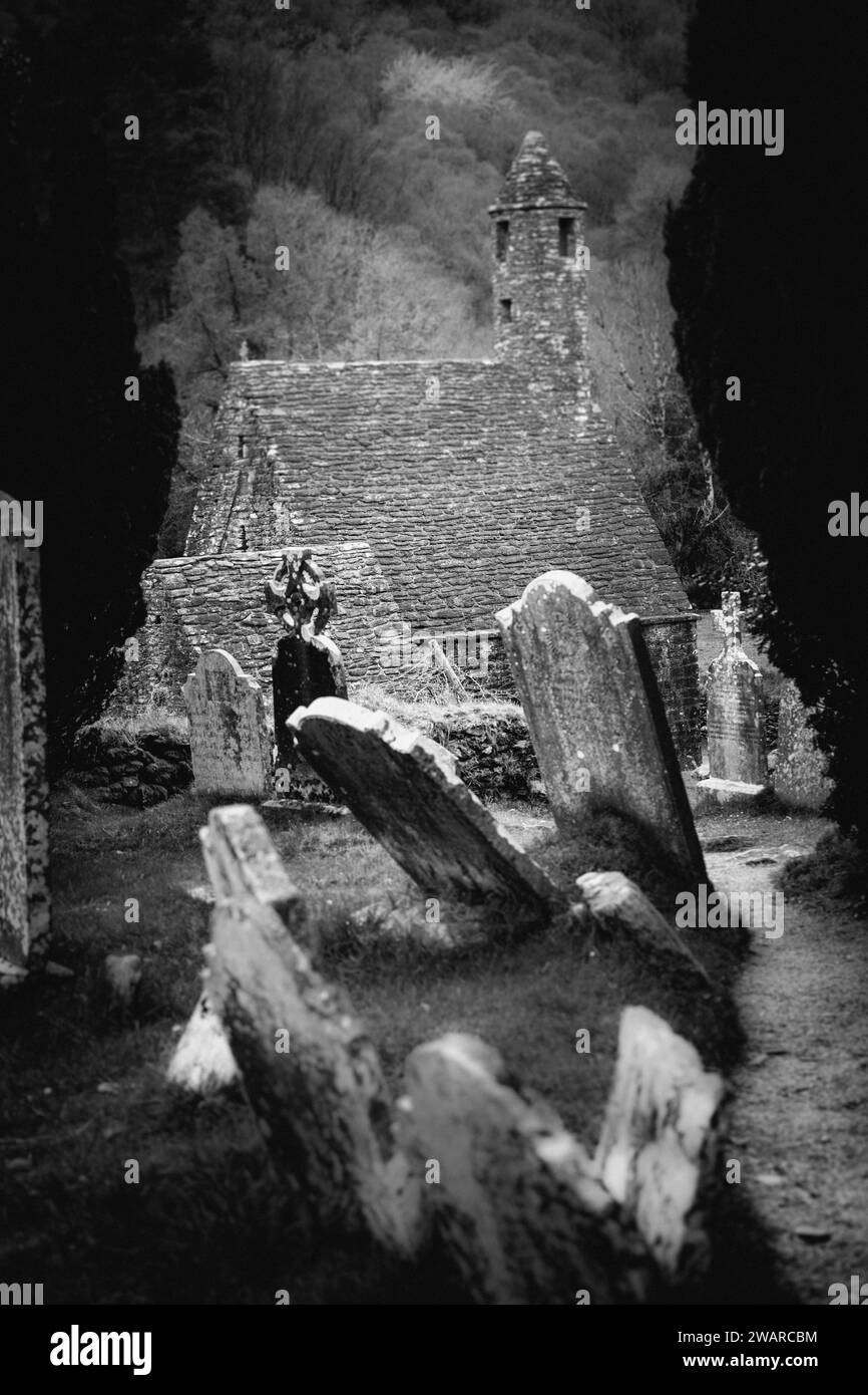 Ein hochauflösendes Schwarzweißbild eines Friedhofs mit zahlreichen Grabsteinen und Statuetten im Vordergrund Stockfoto