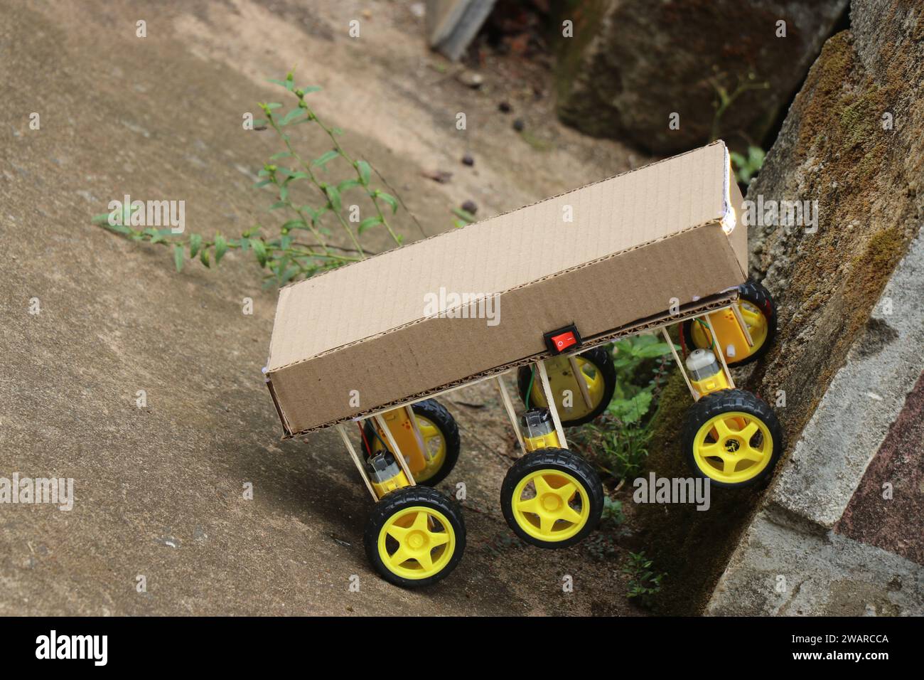 Roboterwagen mit sechs Rädern, gebaut für ein Wissenschaftsprojekt, das versucht, eine kleine Mauer zu erklimmen, um sein Drehmoment zu demonstrieren Stockfoto