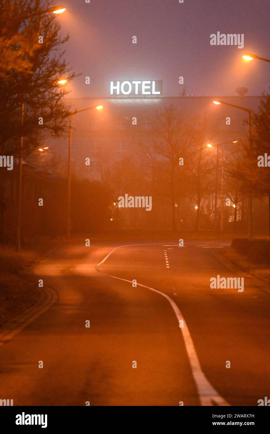 Leipzig - Nebeliger Start in den Samstagabend 06.01.2024 gegen 17 Uhr Leipzig, Messe-Allee im Foto: Eine Straße wird bei Nebel beleuchtet. Im Hintergrund ist ein Schild mit der Aufschrift Hotel zu lesen. In der Nacht zu Sonntag bleibt der Himmel in Sachsen bedeckt, teilweise ist es neblig - wie auch in Leipzig. Stellenweise schneit es leicht, dabei kann es glatt sein. Die Tiefstwerte liegen zwischen -2 und -4 Grad. Leipzig Sachsen Deutschland *** Leipzig Nebel Start zum Samstagabend 06 01 2024 um 17 Uhr Leipzig, Messe Allee auf dem Foto wird im Nebel im Hintergrund Eine Straße beleuchtet Stockfoto