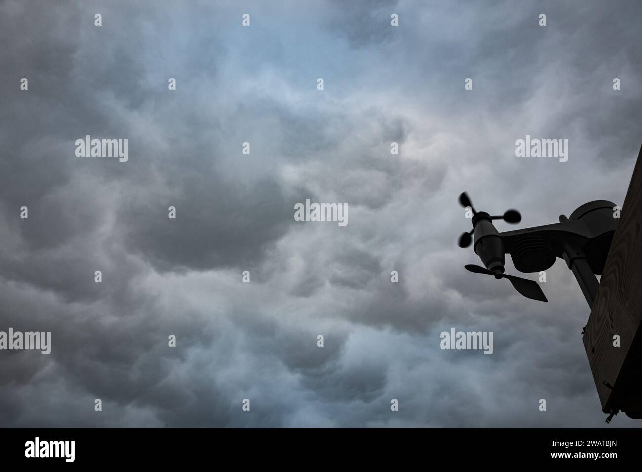 Ein sich schnell drehender Windmesser unter den turbulenten Wolken eines schweren Gewitters. Stockfoto