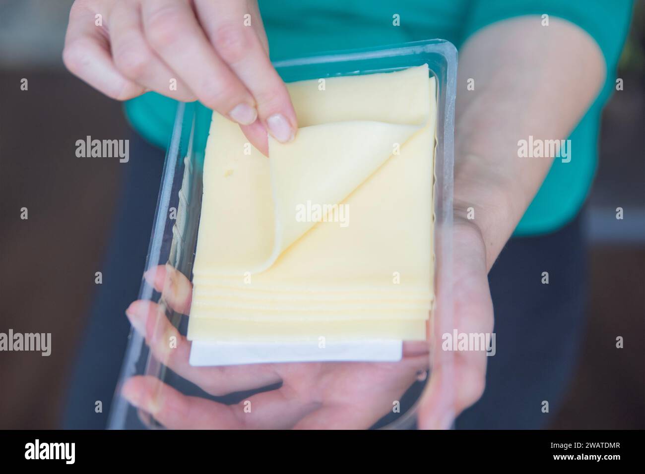 Hand hält Mozzarella-Käse Nahaufnahme. Der Prozess der Zubereitung von Sandwiches. Ein schneller Snack in Form von Käse. Stockfoto