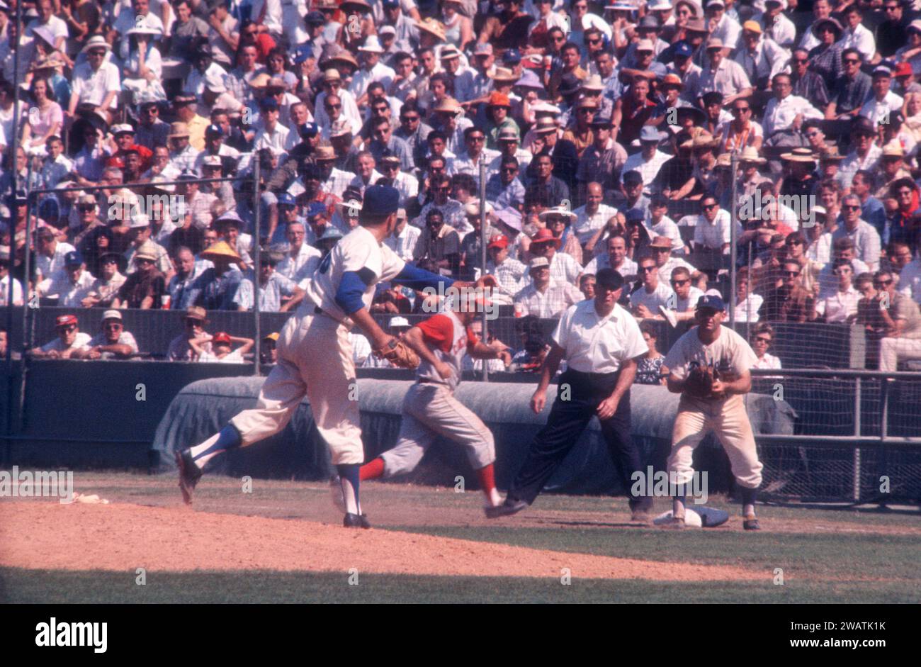LOS ANGELES, KALIFORNIEN – 9. JULI: Pitcher Ron Perranoski #16 der Los Angeles Dodgers wirft auf den ersten Baseman Norm Larker #5, als Gene Freese #12 der Cincinnati Reds auf den ersten Platz zurückgeht, als der Schiedsrichter Tom Gorman während eines MLB-Spiels am 9. Juli auf den ersten Blick sieht. 1961 im Los Angeles Memorial Coliseum in Los Angeles, Kalifornien. (Foto von Hy Peskin) *** örtlicher Bildtitel *** Ron Perranoski;Norm Larker;Gene Freese;Tom Gorman Stockfoto