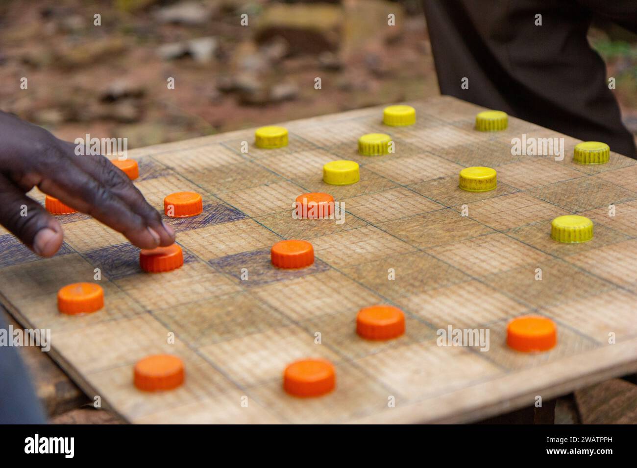 Ugandische Männer spielen Entwürfe (Checker) mit Kunststoff Flasche Kappen als Stücke dienen. Stockfoto