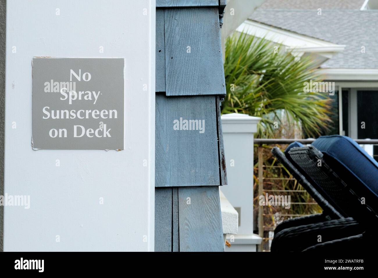 Schild Warnung Besucher: Kein Sonnenschutzmittel auf Deck sprühen; Sonnenschutzmittel können dauerhafte Flecken auf Kunststoffdecks oder Oberflächen aus synthetischem Holz hinterlassen. Stockfoto