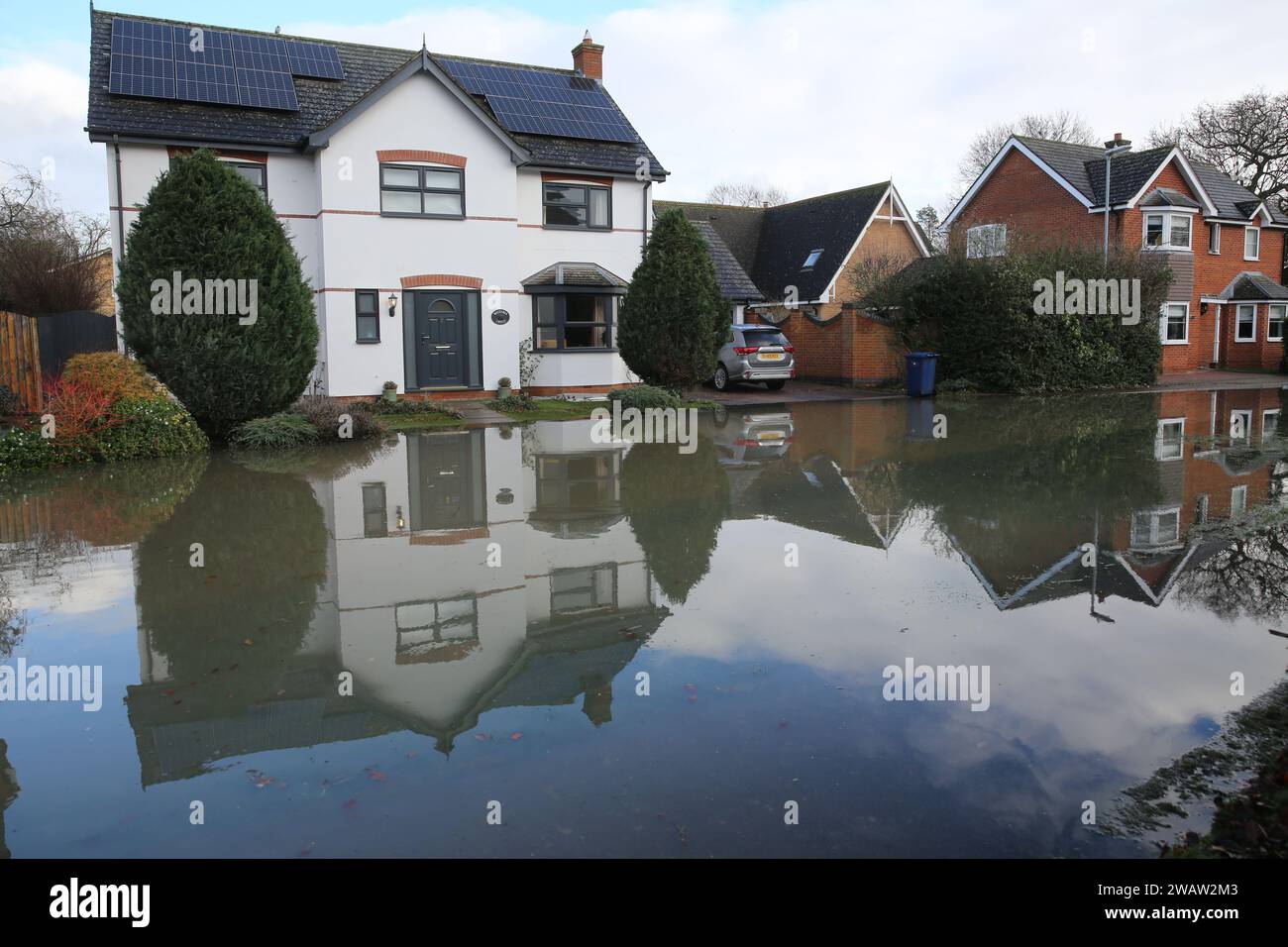 Brampton, Großbritannien. Januar 2024. Häuser säumen den Centenary Way, während Hochwasser die Straße bedeckt, während der Fluss Great Ouse bei Brampton seine Ufer platzt. Hochwasserwarnmeldungen bleiben bestehen, da die Gewässer im Osten Englands nach Sturm Henk weiter steigen. Die wichtigsten Flüsse der Fluss Great Ouse und der Fluss Nene sind über ihre Ufer geplatzt und in die umliegende Landschaft gespült, und mit voll ausgelasteten Abflüssen werden sie wieder in Wohngebieten eingesetzt. Quelle: SOPA Images Limited/Alamy Live News Stockfoto