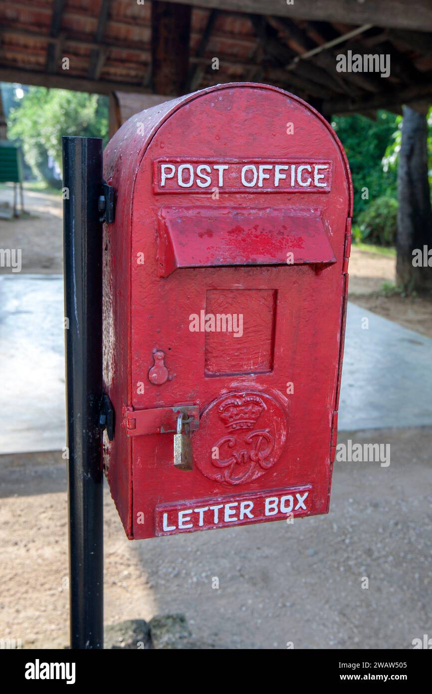 Ein ehemaliger roter Briefkasten des britischen Empire, der noch in Dabakolapatuna in der Region Jaffna im Norden Sri Lankas verwendet wird. Stockfoto