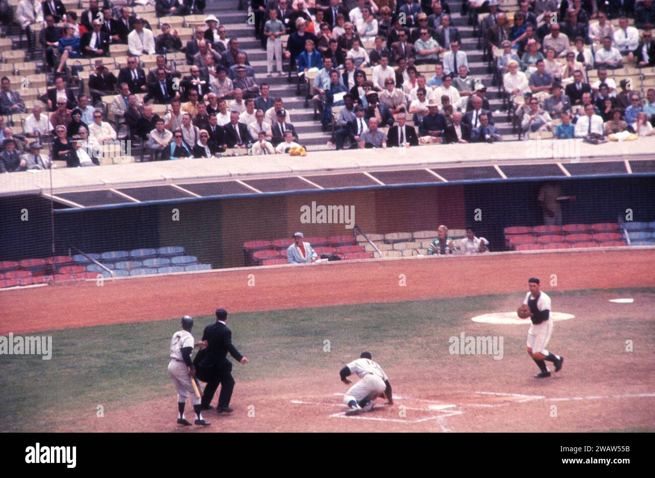 LOS ANGELES, CA - 13. JUNI: Earl Battery #10 der Minnesota Twins punktet als Teamkollege Lenny Green #7 aus der Batters Box zurückkehrt, als der Catcher Buck Rodgers #7 der Los Angeles Angels den Ball während eines MLB-Spiels am 13. Juni 1962 im Dodger Stadium in Los Angeles, Kalifornien, holt. Der Schiedsrichter ist Bill McKinley. (Foto von Hy Peskin) *** örtlicher Bildtitel *** Earl Battery;Lenny Green;Buck Rodgers;Bill McKinley Stockfoto