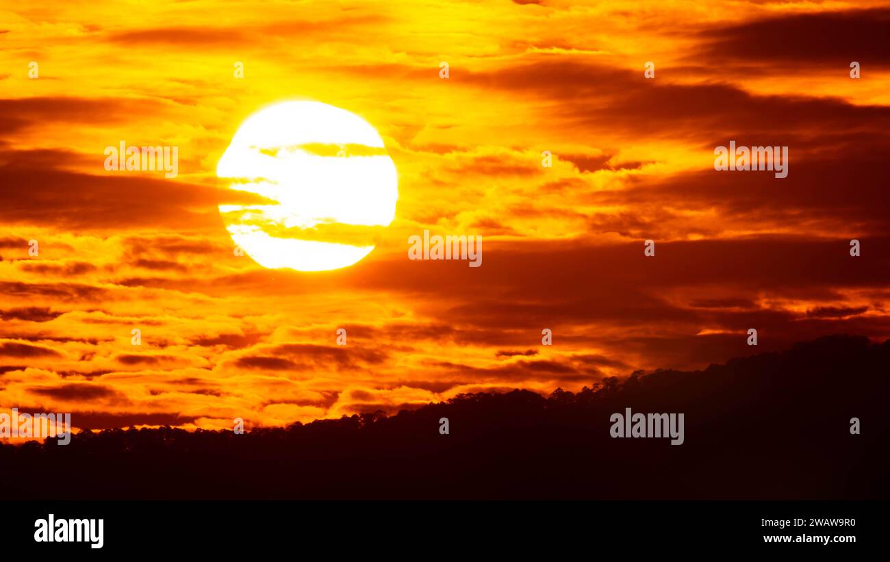 Zeitraffer des wunderschönen Himmels mit Wolken bei Sonnenuntergang. Sonnenuntergangshimmel in der Abenddämmerung mit natürlichem Himmel Hintergrund mit goldenen orangen Wolken. Stockfoto
