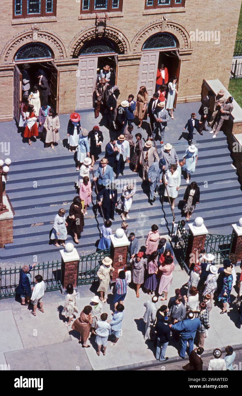 Moderne orthodoxe jüdische Männer und Frauen verlassen ihre Synagoge am Ende der Samstagvormittagsgottesdienste. An der 14th Avenue in Borough Park, Brooklyn, New York um 1976. Stockfoto