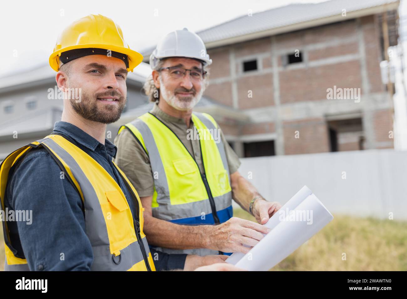 Junger Mann Arbeiter Bauingenieur männlich arbeitet mit leitendem Projektleiter auf der Baustelle Happy Smile. Stockfoto