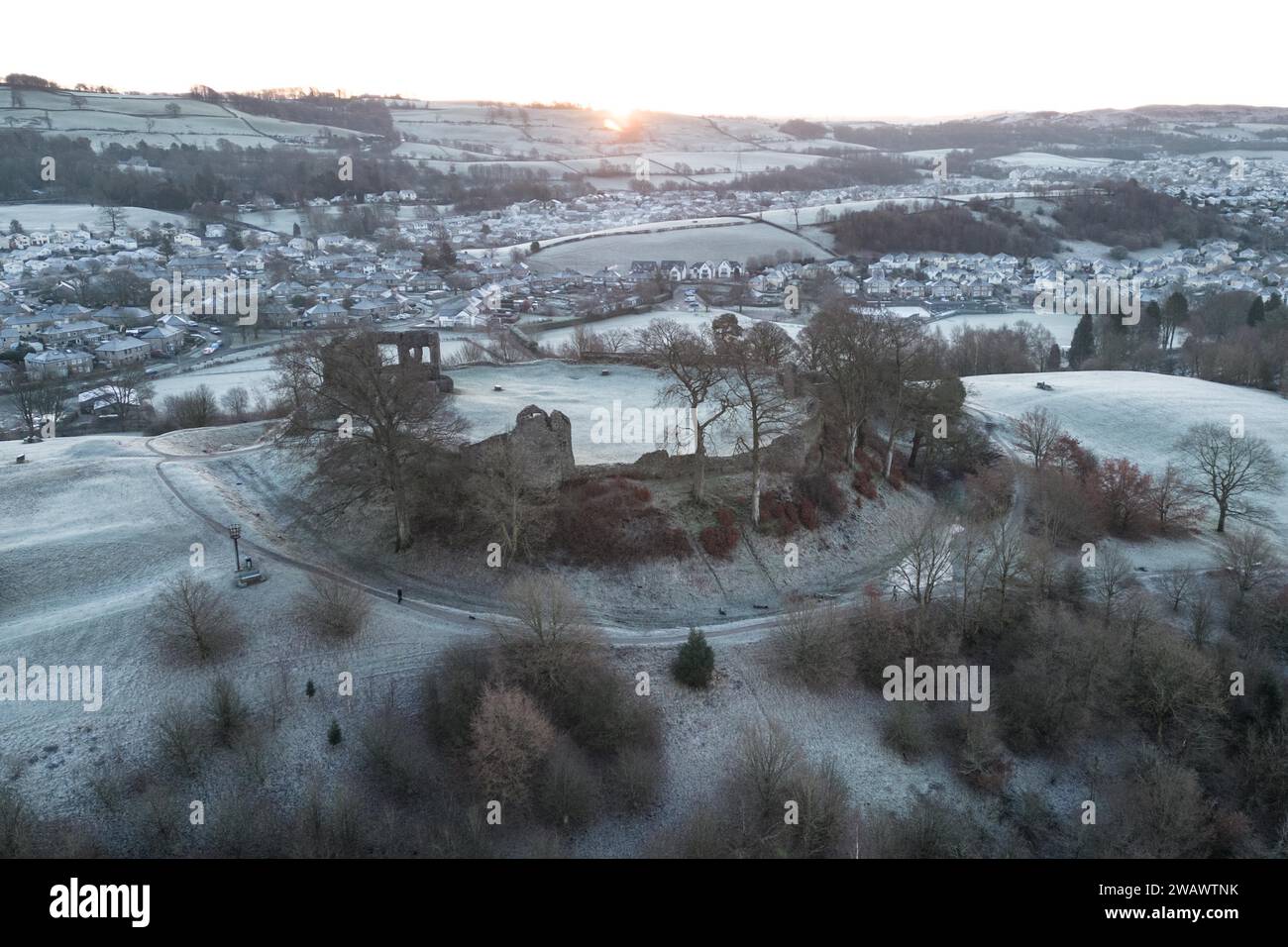 Kendal, Cumbria, 7. Januar 2024 - Eine Nacht mit Nebel und Temperaturen unter Null brachte am Sonntag einen wunderschönen winterlichen Morgenfrost in die Stadt Kendal in Cumbria. Kendal Castle, das die mittelalterliche Stadt überblickt, war von einer weißen Eisschicht umgeben, während Hundeschlittenläufer die Aussicht genossen. Die Häuser am Fuße der Burg sind kreisförmig geformt und auch die Ovale fangen den Frost ein. Quelle: Stop Press Media/Alamy Live News Stockfoto