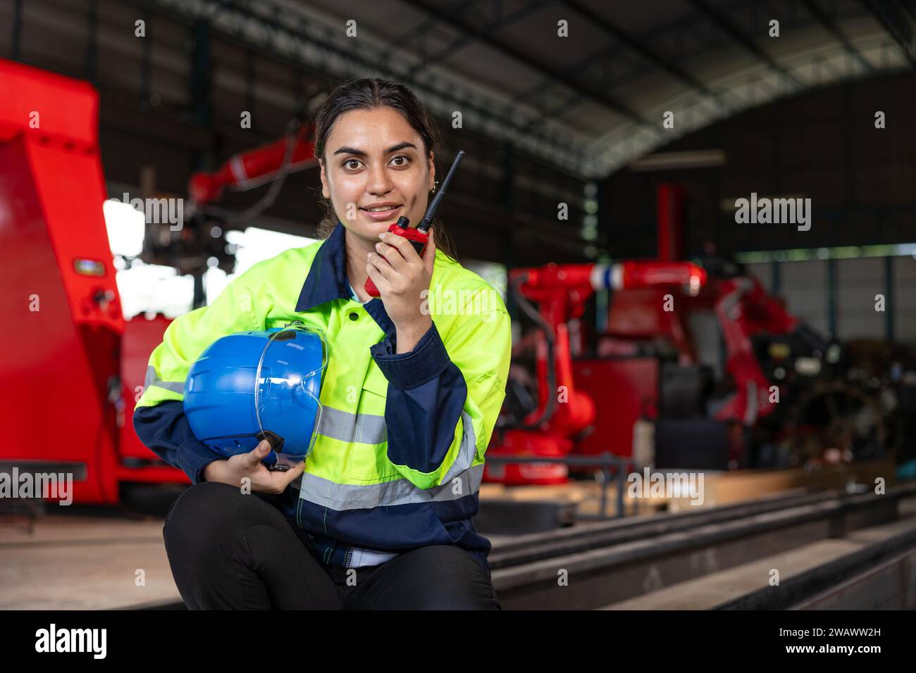 Ingenieur-Frau intelligente indische Arbeiter-Aufsichtsperson mit Sicherheitsanzug Arbeit in Roboter-Metallmaschinen-Fabrik-Bediener Funksteuerung. Stockfoto